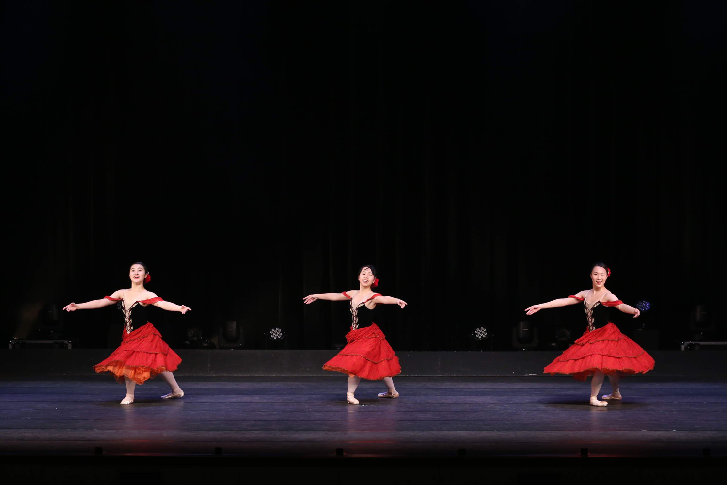 赤の衣装をアクセントにし、広いステージでも一体感生み出すバレエダンサー達